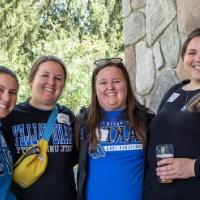 4 Alumnae pose together outside of the Alumni House and Visitor Center